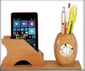 wooden table top a clock with mobile and pen